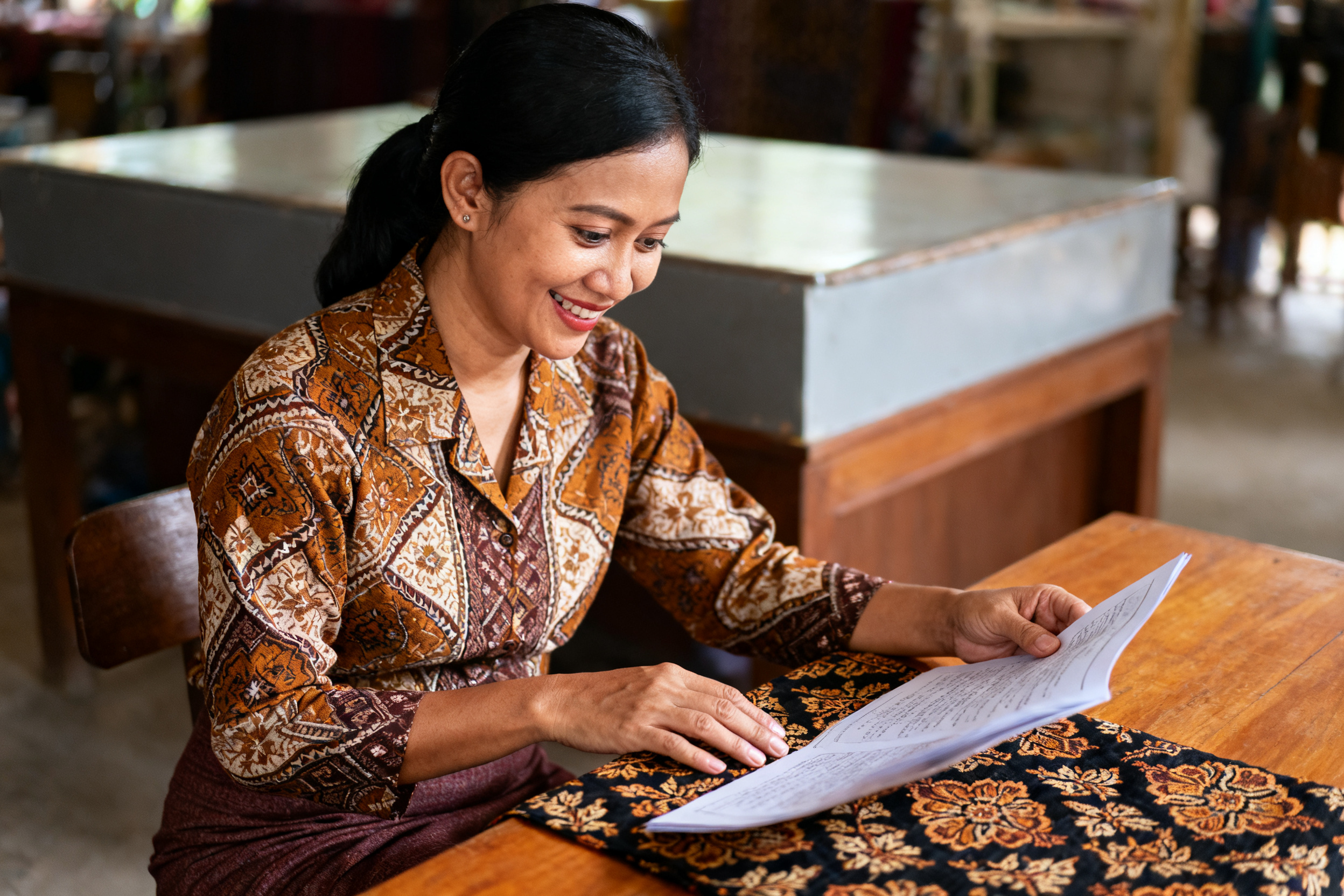wawasan budaya lokal Indonesia ditunjukkan lewat wanita Indonesia memeriksa kain batik tradisional